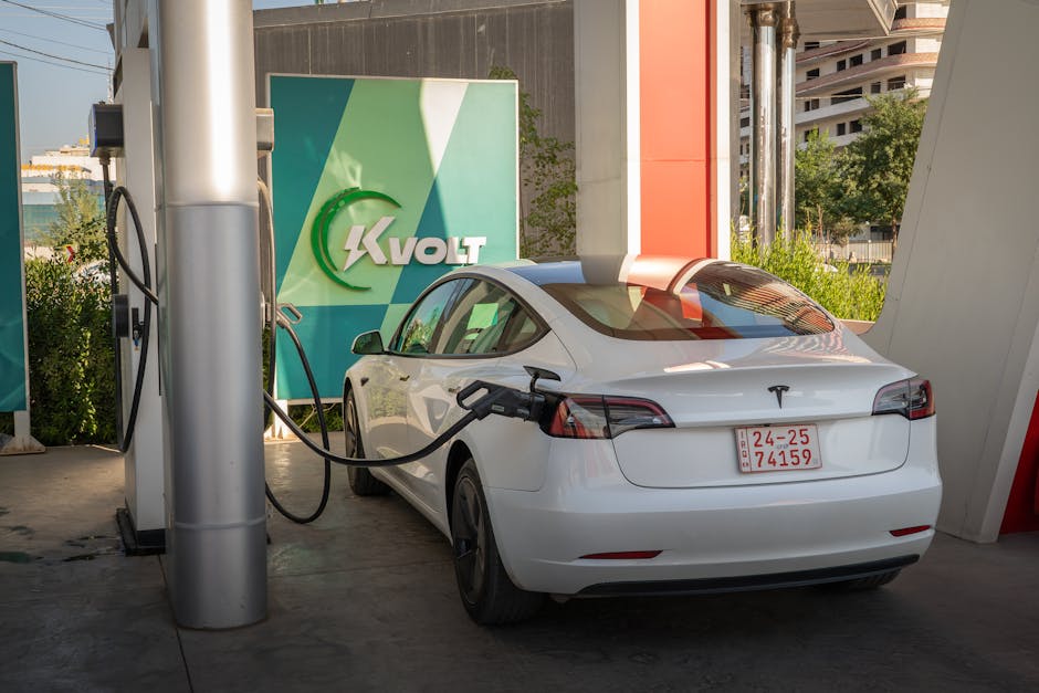 A white Tesla Model 3 charging at an outdoor electric vehicle station with Kvolt branding.