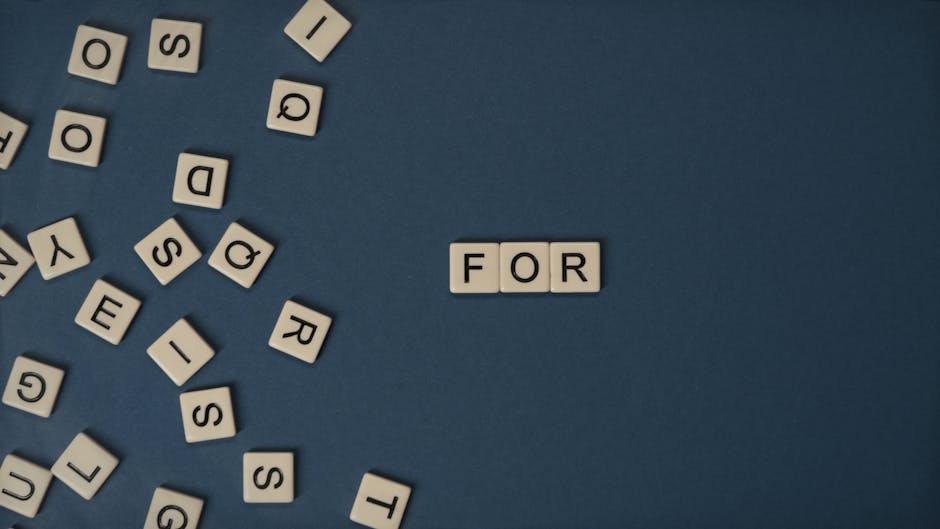 Alphabet tiles scattered on blue surface spelling the word 'FOR' with ample copy space for text.