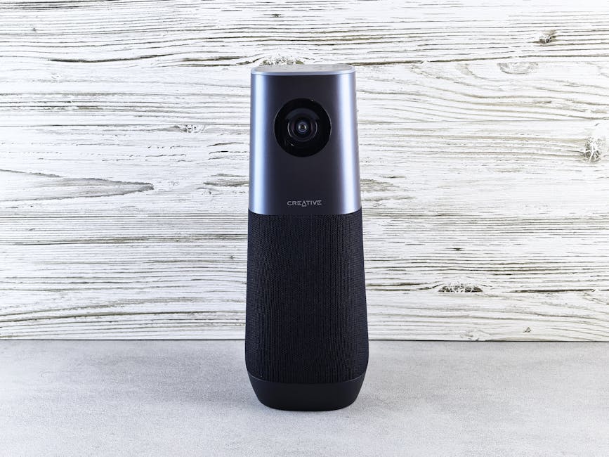 A sleek smart speaker with an integrated camera against a wooden backdrop, perfect for modern tech setups.