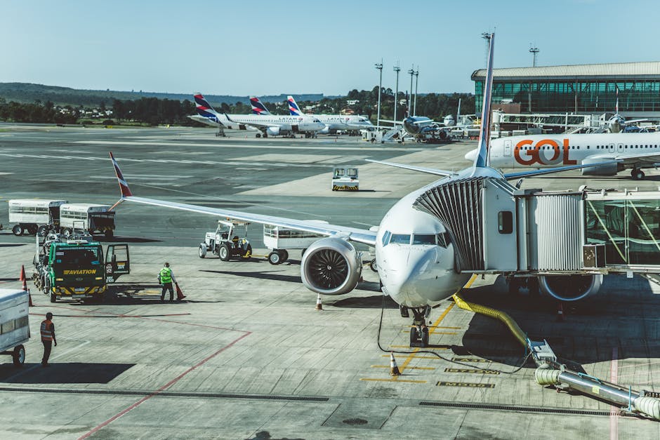 A scenic view of airplanes at an airport runway during a busy day, ready for boarding.