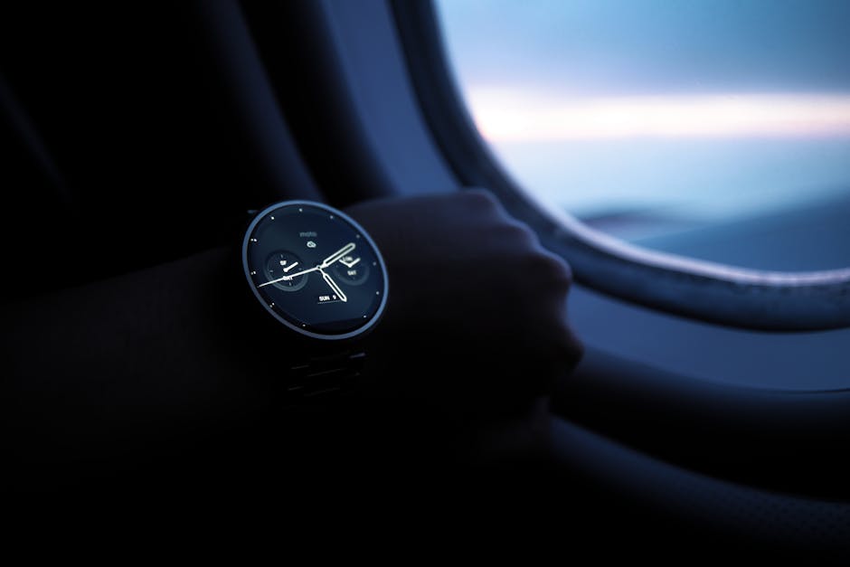A smartwatch on a wrist shown against an airplane window view during flight.