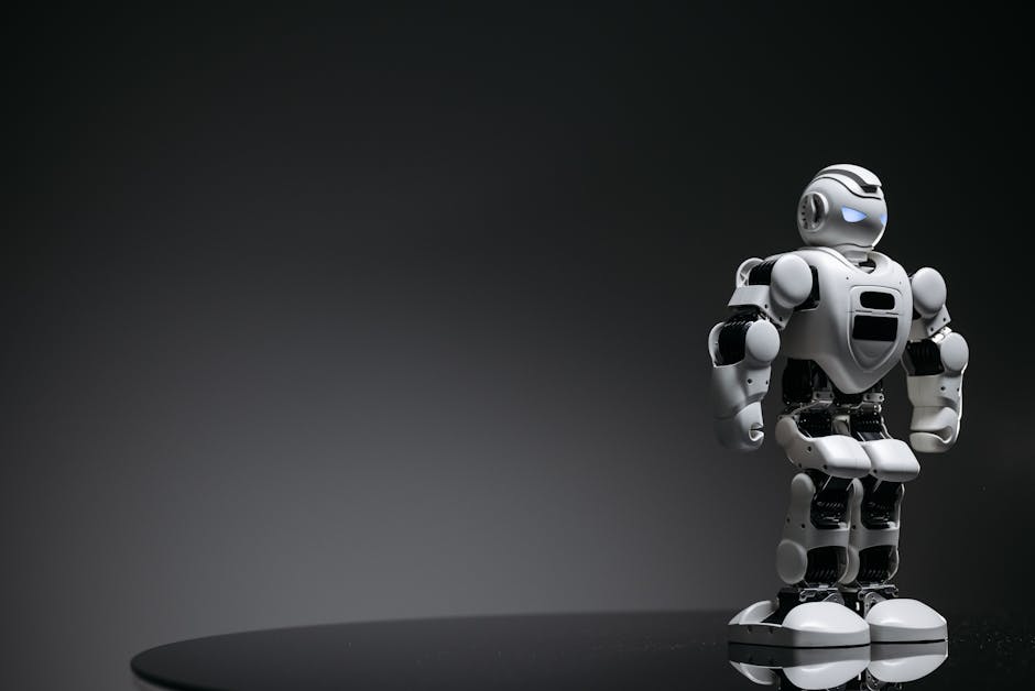 Compact humanoid robot toy standing on a reflective surface, exuding a futuristic vibe.