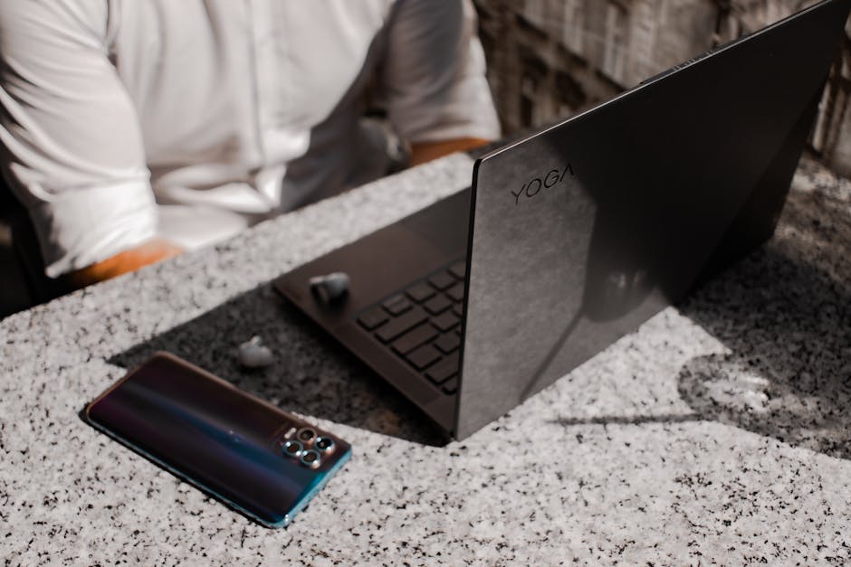 A sleek laptop and smartphone placed on a granite table outdoors, perfect for remote working.