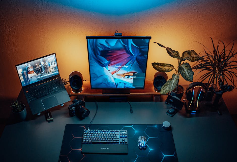 Sleek home office with dual screens, keyboard, mouse, and plants, illuminated by ambient lighting.