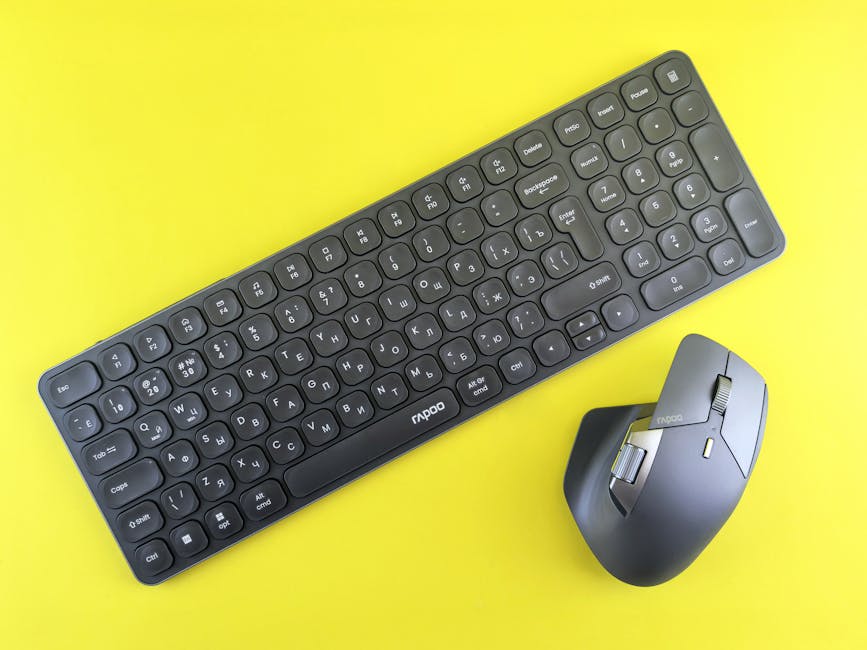 Modern wireless keyboard and mouse set against a vibrant yellow background, showcasing sleek design.