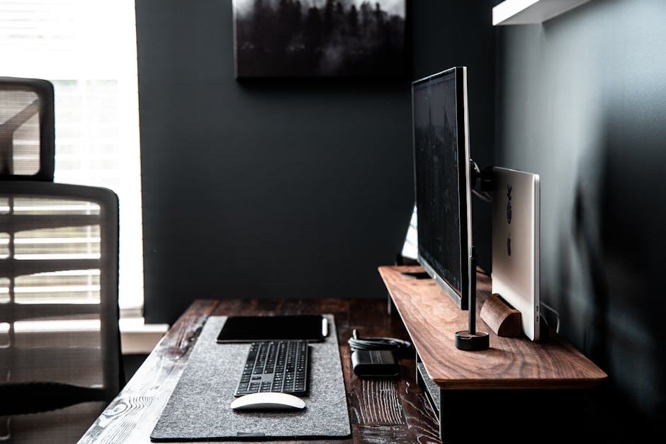 Stylish modern workspace with desktop computer, keyboard, and chair.