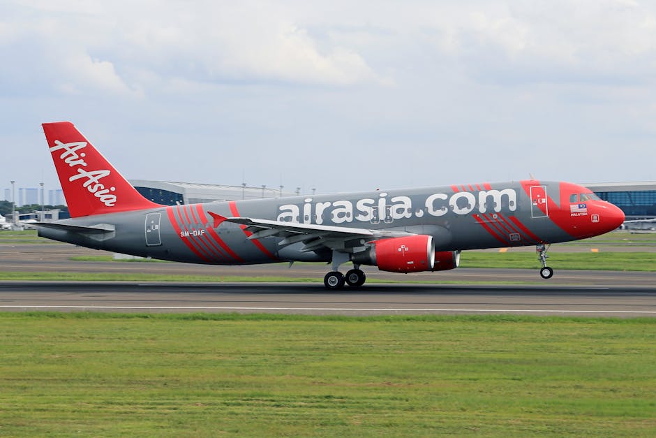 AirAsia plane taking off on runway at a busy airport, showcasing aviation and travel.