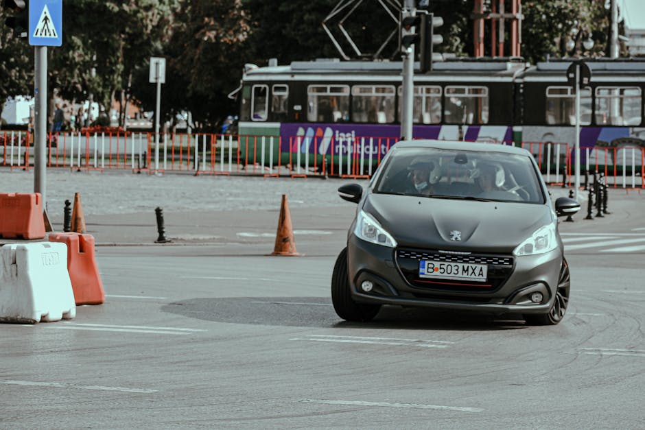 A sleek car performs a drift in an urban environment with a tram in the background.