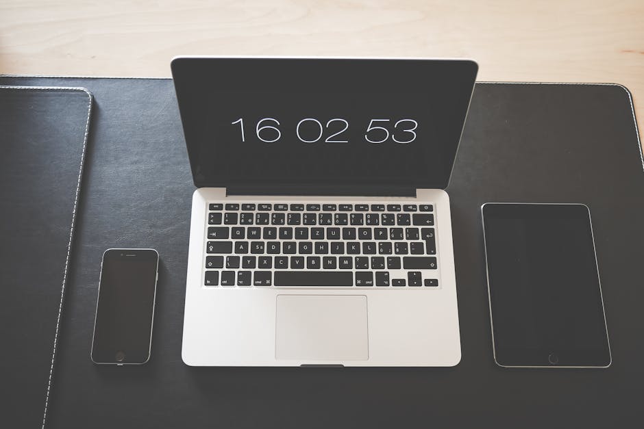 A sleek office desk featuring a laptop, smartphone, and tablet, symbolizing modern technology.