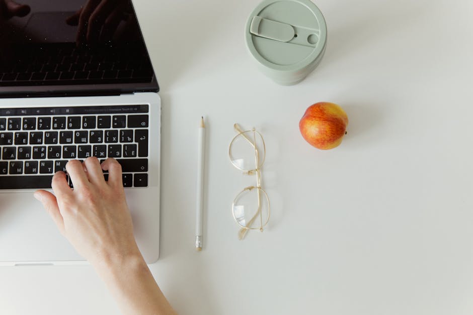 Simple minimalist workspace with a laptop, coffee cup, and apple. Ideal for office theme.
