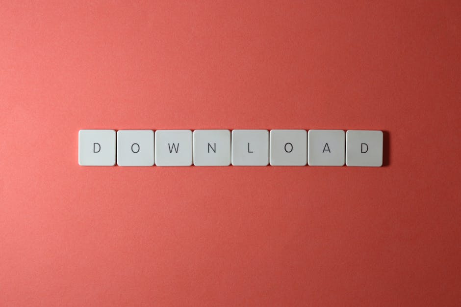 Minimalist photo of keyboard tiles spelling 'DOWNLOAD' on a red background.