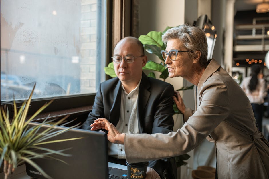 Senior professionals discussing a project at a modern office workspace.