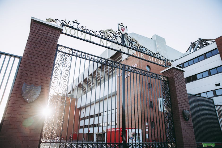 A photo capturing the iconic gates of Anfield Stadium, Liverpool, with sunrays illuminating the architecture.